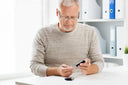 Older male reading his blood test to check his diabetes