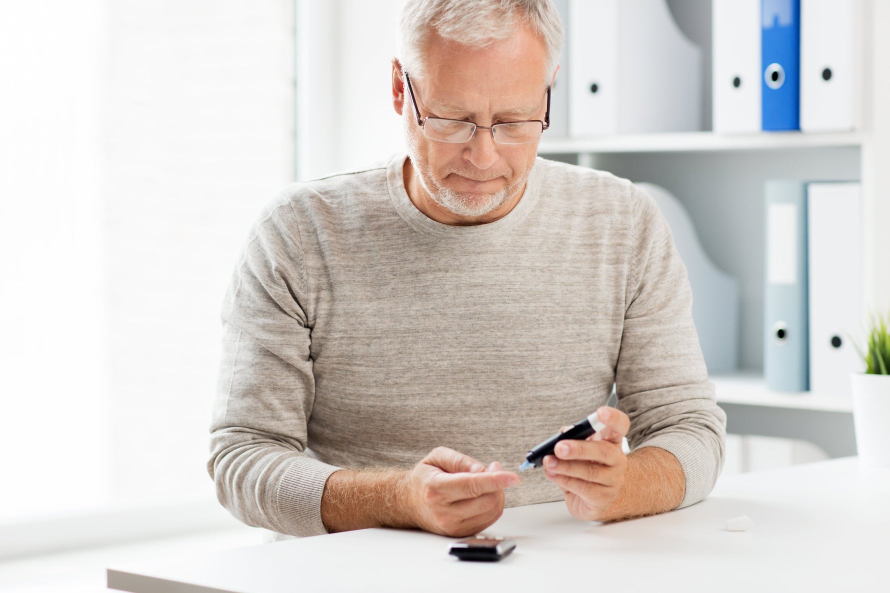 Older male reading his blood test to check his diabetes
